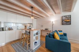 een woonkamer met een blauwe bank en een keuken bij GuestReady - Ladder Mezz in Porto