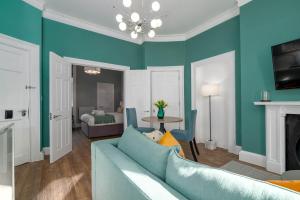 een woonkamer met een blauwe bank en een tafel bij 37 Doughty Street in Londen