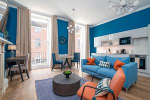 een woonkamer met blauwe muren en een blauwe bank bij 37 Doughty Street in Londen