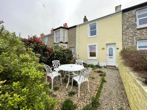 a table and chairs in front of a house at Stunning Seaview Cottage in St Just