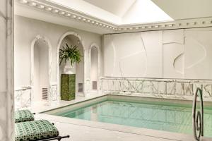 a swimming pool with two chairs and a swimming pool at Saint James Paris in Paris
