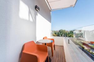 a balcony with orange chairs and a table at Marques Design Apartments in Porto