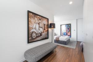 a room with a bed and a picture of a scooter on the wall at Marques Design Apartments in Porto