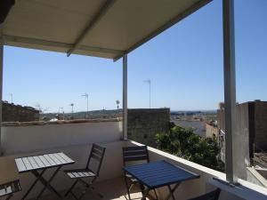 a patio with two tables and chairs on a balcony at B&B Vinci in Noto