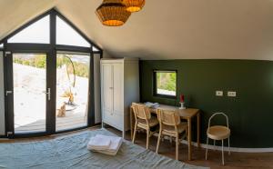 a dining room with a table and chairs and a window at My Little Village in Poiana Mărului