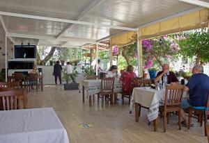 un grupo de personas sentadas en mesas en un restaurante en UMAYRA OTEL, en Bodrum City