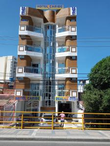 dos personas parados frente a un edificio en Hotel Caribe Real Inn, en Santa Marta