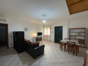 ein Wohnzimmer mit einem Sofa und einem Tisch in der Unterkunft Appartamento Centrale in Olbia