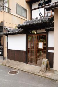 una puerta a un edificio con un cartel delante en HEM'S HOTEL 1日1組限定 new en Miyajima