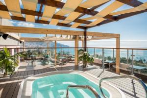 - une piscine sur une terrasse avec vue sur l'océan dans l'établissement TUI Blue Gardens - Adults-only - Savoy Signature, à Funchal