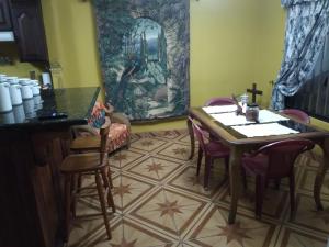uma sala de jantar com mesa e cadeiras em Alexander b&b em Alajuela