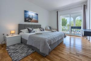 a white bedroom with a bed and a piano at Apartment Villa Zdenka in Crikvenica +38 photos