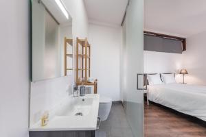 baño con lavabo, cama y espejo en GuestReady - Redamancy Flat, en Oporto