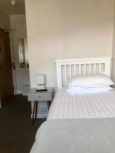 um quarto com uma cama e uma mesa com um candeeiro em Cranwell Court Apartments em Aberystwyth