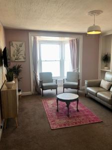 阿伯里斯特威斯的住宿－Cranwell Court Apartments，客厅配有沙发和桌子