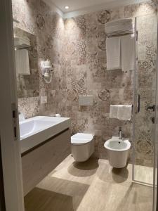 a bathroom with a tub and a toilet and a sink at EUROPA Hotel in Vasto