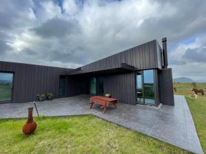 a black house with a bench in front of it at Fögruvellir Country House in Hella