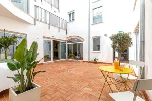 Residencia Demar في Godella: ساحة مفتوحة مع طاولة صفراء ونباتات