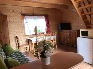 a living room with a table and a kitchen at Domki KANZAS in Sławno