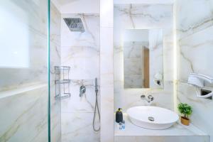 a white bathroom with a sink and a shower at Serenity Apartments in Skala Potamias +44 photos