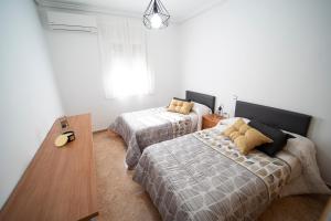 1 dormitorio con 2 camas y ventana en TOLEDO A TIRO, en Bargas