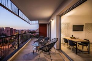 馬拉喀什的住宿－M Appart，设有一个配有桌椅并享有美景的阳台。