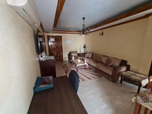 sala de estar con sofá y mesa en Figuig Appart'Hotel en Rabat