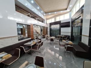 un restaurante con mesas y sillas en una habitación en Figuig Appart'Hotel en Rabat