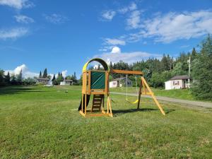 a playground with a slide in a field at Ladd Pond Cabins and Campground, LLC in Colebrook
