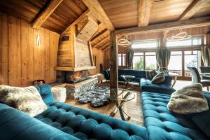 salon z niebieskimi kanapami i kominkiem w obiekcie Luxury Chalet Morzine with stunning mountain views w mieście Saint-Jean-dʼAulps