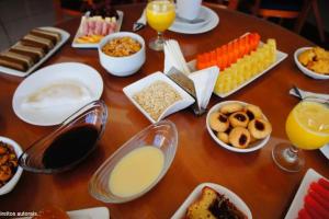 a wooden table topped with different types of food at Flat espaçoso na orla de Tambaú - Nobile Suítes in João Pessoa