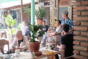 a group of people sitting at tables in a restaurant at Abrakadabra 747 in Yogyakarta