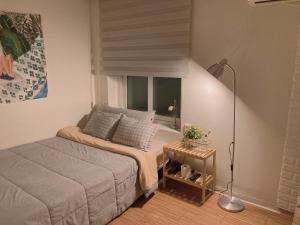 a small bedroom with a bed and a window at Yakorea Hostel Dongdaemun in Seoul