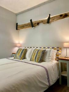 1 dormitorio con 1 cama blanca y 2 almohadas en Serendipity Eymet B&B, en Eymet