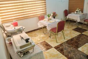 a restaurant with two tables and chairs and a table with food on it at Covenant Hotel in Accra