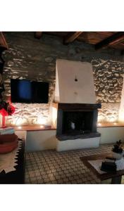 a living room with a fireplace and a flat screen tv at Casa Vacanze Al Colletto - Con terrazza panoramica in centro storico in Vagli di Sotto