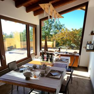 een eetkamer met 2 tafels en een groot raam bij Le Querce Dell'Etna B&B in Ragalna
