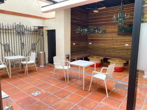 a patio with tables and chairs on a tile floor at BCN Urbaness Hotels Bonavista in Barcelona