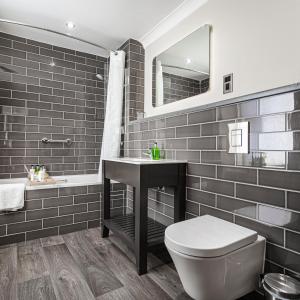 a bathroom with a toilet and a sink and a mirror at The Castle Hotel, Conwy, North Wales - The Coaching Inn Group in Conwy