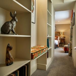 a walk in closet with a stuffed rabbit on the shelves at The Castle Hotel, Conwy, North Wales - The Coaching Inn Group in Conwy