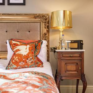 a bedroom with a bed with a lamp and a pillow at The Castle Hotel, Conwy, North Wales - The Coaching Inn Group in Conwy