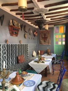 een eetkamer met 2 tafels en een bank bij Riad Blue Berber in Marrakesh