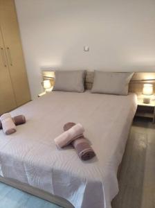 1 cama blanca grande con 2 toallas en City Comfort Apartment, en Preveza