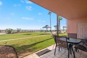 a patio with a table and chairs and a view of the ocean at Doral 103 - Charming Beachfront / Ground Floor Condo! in Gulf Shores