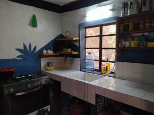 a kitchen with a sink and a stove and a window at Chez Yaya - Grande Chambre in Oussouye