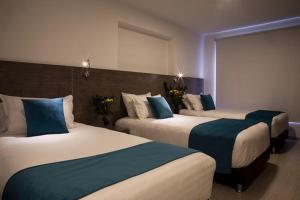 a hotel room with two beds with blue pillows at 7hotel in San Salvador