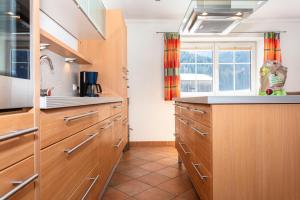 a kitchen with wooden cabinets and a window at Chalet Habachtal - Wildkogel in Bramberg am Wildkogel