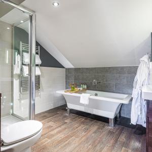 a bathroom with a tub and a toilet and a sink at The Castle Hotel, Conwy, North Wales - The Coaching Inn Group in Conwy