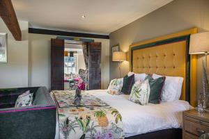 a bedroom with a large bed with a large headboard at The Castle Hotel, Conwy, North Wales - The Coaching Inn Group in Conwy