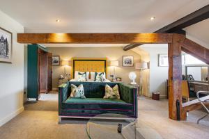 a living room with a green couch and a bed at The Castle Hotel, Conwy, North Wales - The Coaching Inn Group in Conwy
